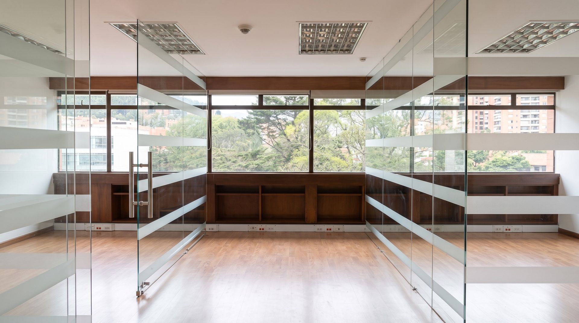 Oficinas con divisiones de vidrio y ventanal