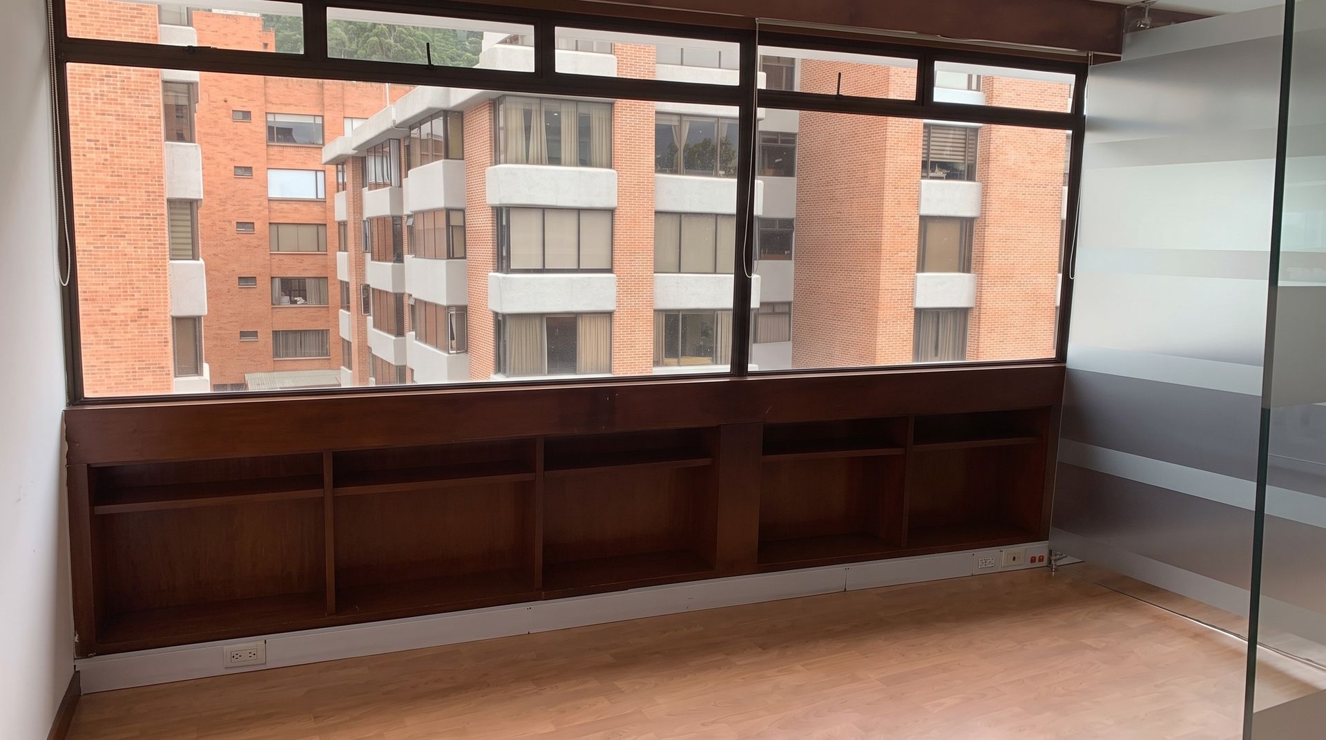 Oficina con ventanal corrido hacia los edificios del norte